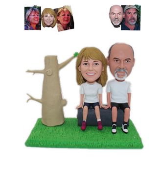 Customized Bobblehead Couple Sitting on A Stone Next To A Tree